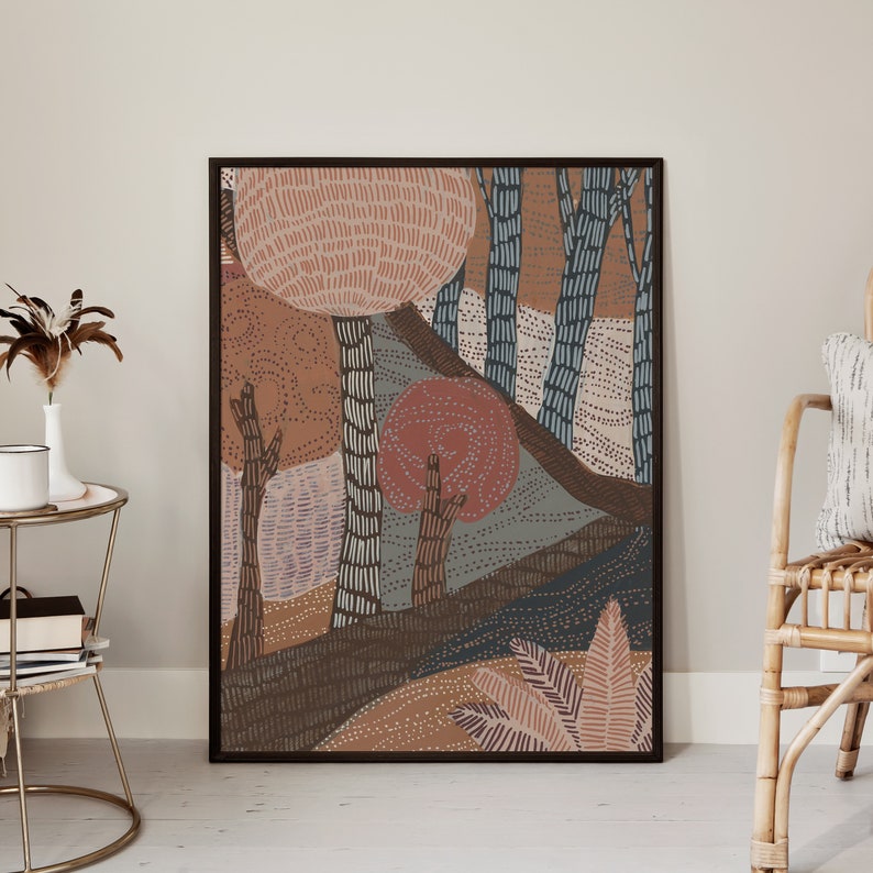 May include: Abstract art print featuring a stylized forest scene with trees, leaves, and a red sun. The print is framed in a black frame and has a brown, orange, and blue color scheme.