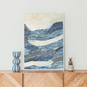 Puede incluir: Una pintura abstracta enmarcada con un patr&oacute;n de rayas azules y blancas. La pintura est&aacute; enmarcada en un marco blanco y est&aacute; colgada en una pared blanca.