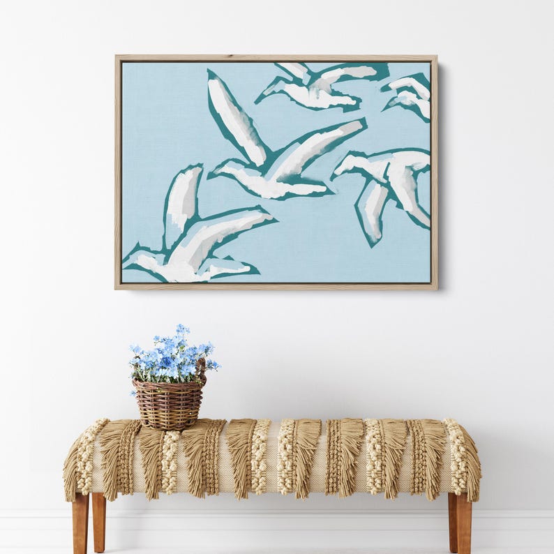 May include: A framed abstract painting of white birds flying in a light blue sky. The birds are stylized and have a teal outline.