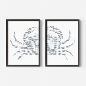 May include: Two black framed prints of a stylized crab design in blue on a white background.
