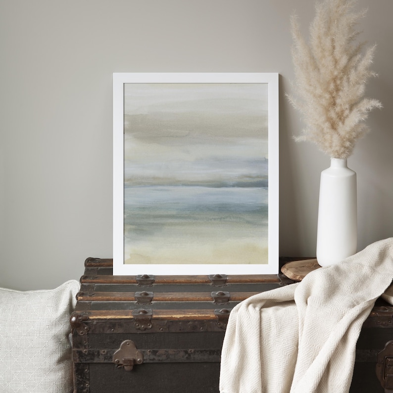 May include: A framed abstract painting with a muted color palette of blues, greens, and grays. The painting depicts a hazy, atmospheric landscape with a horizontal line representing a horizon or water.