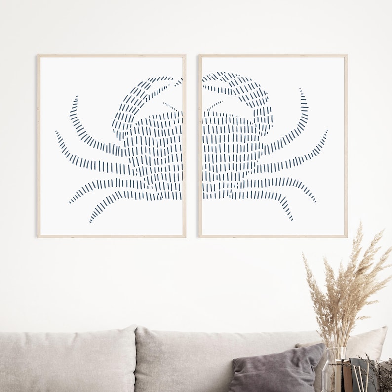 May include: Two framed prints of a stylized crab design in a dark blue color on a white background.