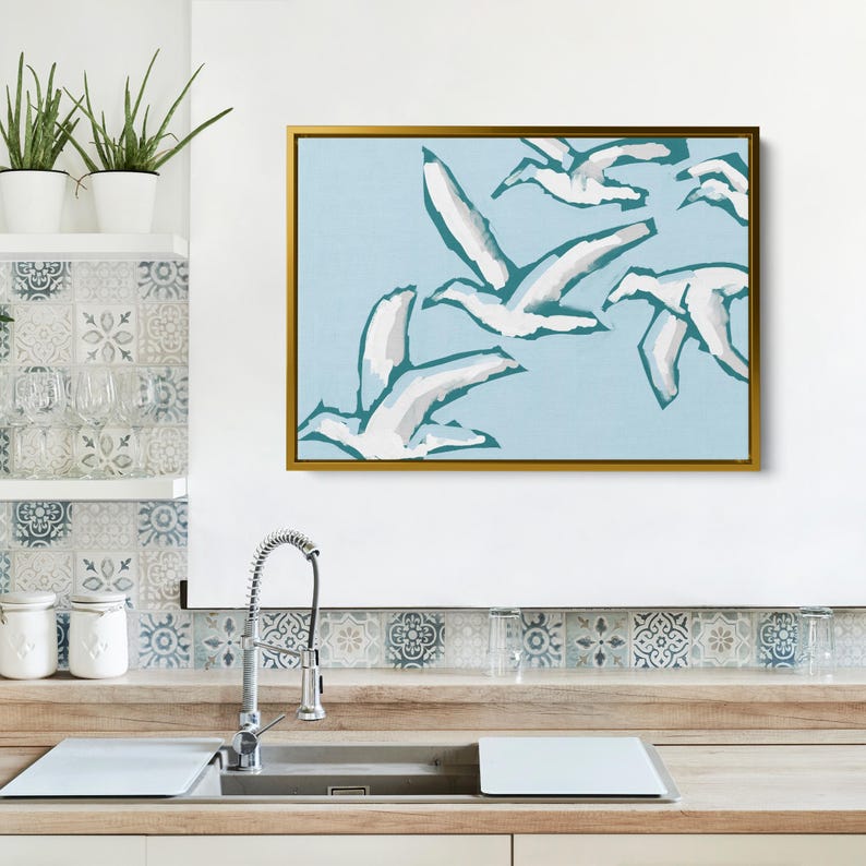 May include: A framed abstract painting with a light blue background and white and teal stylized birds flying in formation.