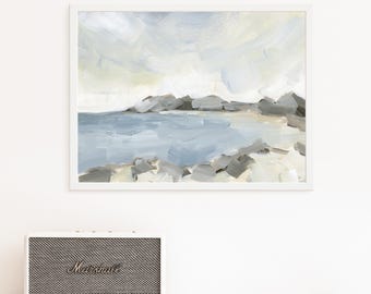 May include: Abstract landscape painting in a white frame. The artwork depicts a coastal scene with a blue-gray sea, rocky shore, and a cloudy sky. The painting uses broad brushstrokes in shades of gray, blue, and beige. A Marshall speaker is below the painting.