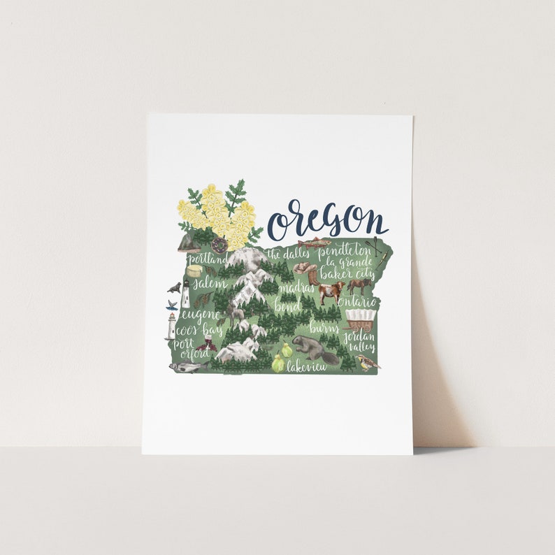 May include: A green and yellow illustration of the state of Oregon with the name "Oregon" written in blue cursive at the top. The illustration includes the names of major cities and towns in Oregon, such as Portland, Salem, Eugene, and Bend.