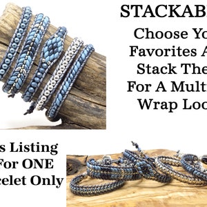 K&ouml;nnte beinhalten: Ein Set aus f&uuml;nf stapelbaren Perlenarmb&auml;ndern in Blaut&ouml;nen und Silber. Die Armb&auml;nder sind aus kleinen Perlen gefertigt und haben einen Lederkordelverschluss. Der Text "STACKABLES Choose Your Favorites And Stack Them For A Multiple Wrap Look!" wird &uuml;ber den Armb&auml;ndern angezeigt. Der Text "This Listing Is For ONE Bracelet Only" wird unter den Armb&auml;ndern angezeigt.