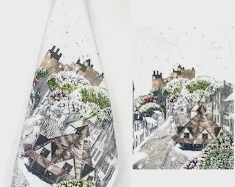 Könnte beinhalten: Ein weißes Küchentuch mit einer detaillierten Illustration einer winterlichen Dorfszene mit einer Burg auf einem Hügel, verschneiten Bäumen und Häusern. Das Wort WINTER ist in der unteren rechten Ecke in einfacher Schrift gedruckt.