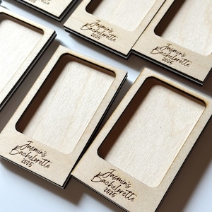 May include: A collection of wooden photo frames with a rectangular cutout. Each frame has the text "Jasmin's Bachelorette 2025" engraved in a script font. The frames are light-colored wood with a dark border.
