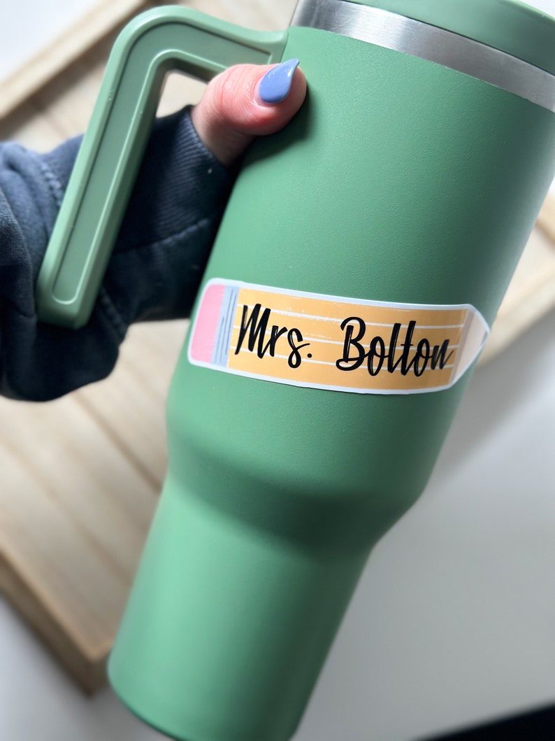 May include: Green travel mug with a pencil-shaped sticker that says "Mrs. Bolton".