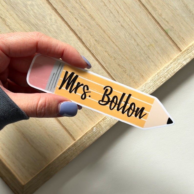 May include: A yellow pencil-shaped sticker with the text "Mrs. Bolton" in black cursive font.