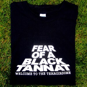 May include: Black t-shirt with white text that reads "Fear of a Black Tannat, Welcome to the TerroirDome".