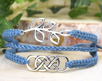 May include: A blue braided bracelet with a silver infinity symbol charm and a silver leaf charm.