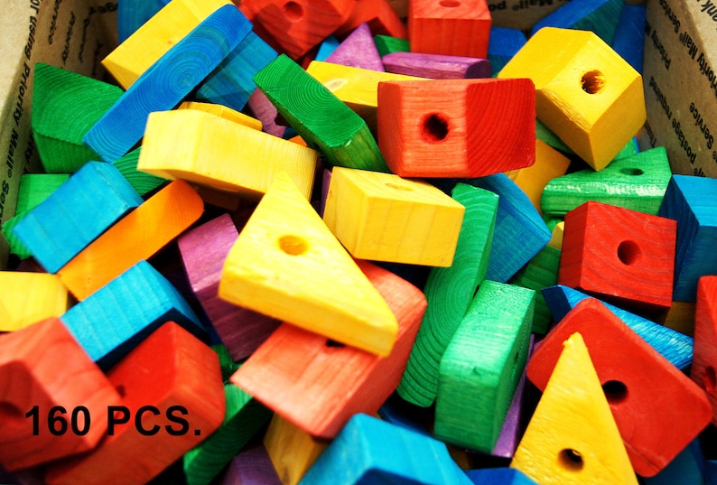Puede incluir: Una gran pila de bloques de madera de colores en varias formas, incluyendo cuadrados, tri&aacute;ngulos y rect&aacute;ngulos. Los bloques est&aacute;n pintados en colores brillantes, incluyendo rojo, amarillo, azul, verde y morado. El texto "160 PCS." es visible en la esquina inferior izquierda de la imagen.