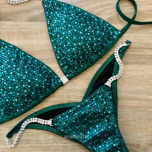 Green Bikini on a table, with silver crystal connectors and a brazilian back coverage included in this sewing pdf pattern for competition bikinis.