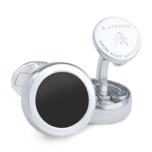 May include: Silver cufflinks with a black onyx centre and the inscription "A.AZOTHOM ACCESSORIES SWISS MADE" on the top.