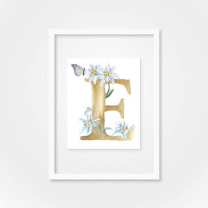 Letra E de acuarela en dorado con flores de edelweiss y una mariposa azul, pintura de acuarela original | Judit Fortelny Bellas Artes