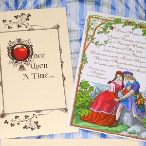 May include: A fairytale wedding invitation with a red apple and the text "Once Upon A Time..." on the front. The back of the invitation features a hand-drawn illustration of a couple in a forest setting with the text "Karis Masters and Joseph Flanigon will unite in a Fairytale Wedding on the first of May, 2016 at three o'clock in the Afternoon. Please join us at the Castle Manor Inn, Gloucester, Massachusetts, to celebrate this union with Feasting and Revelry."