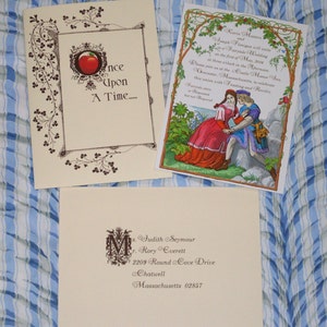 May include: A cream-colored invitation with a brown border and a red apple illustration. The text reads "Once Upon A Time..."