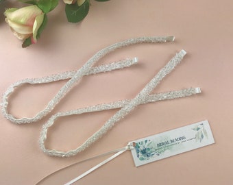 May include: A white beaded sash with a white satin ribbon and a tag that reads "Bridal Beading - Beaded Accessories by Jane Lawrence".