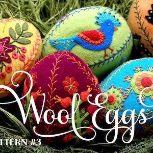 May include: Five colorful wool eggs with embroidered designs. The eggs are arranged in a nest of green grass. The text "Wool Eggs" is written in a decorative font across the front of the image. The text "PATTERN #3" is written in the bottom left corner of the image.
