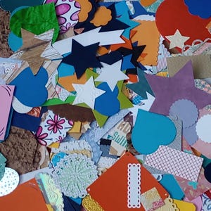 May include: A large assortment of colorful paper shapes, including stars, hearts, and circles. The shapes are made of various textures and patterns, including glitter, polka dots, and floral designs.