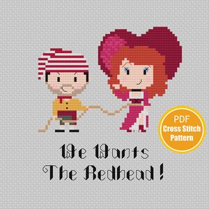 May include: Cross stitch pattern featuring a cartoon couple, a man with a striped hat and a woman with a red heart-shaped hat, pulling on a rope. The text below reads "We Want The Redhead!" and "PDF Cross Stitch Pattern".