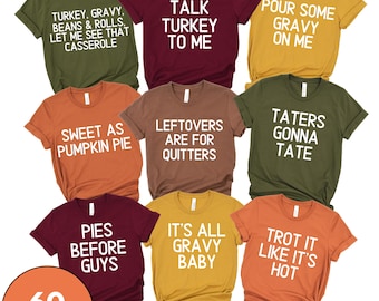 May include: A collection of nine short-sleeve crew neck t-shirts in olive, maroon, mustard, orange, and brown, each featuring white text with various Thanksgiving-themed phrases like Talk Turkey To Me and Taters Gonna Tate.