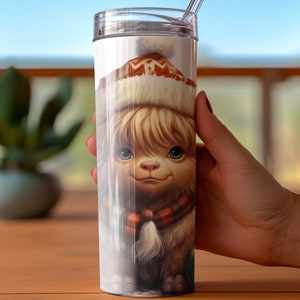 May include: A 20-ounce stainless steel tumbler features a whimsical illustration of a fluffy, light brown creature wearing a warm, patterned winter hat and a red and orange scarf. The creature's eyes are large and expressive, and its overall appearance is cute and endearing. The tumbler is white and has a clear lid with a straw.  The image is high-quality and detailed, showcasing the creature's soft fur and the intricate design of its hat and scarf.