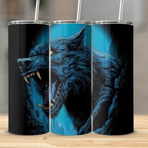 Pode incluir: Três copos de aço inoxidável com um gráfico de lobo azul e preto. O lobo está rosnando com a boca aberta e os dentes à mostra. O fundo é azul escuro com uma textura rochosa.