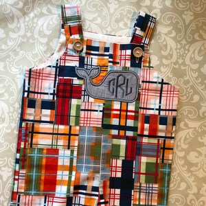 May include: Patchwork plaid dungarees with a whale applique and monogrammed initials "CRL".