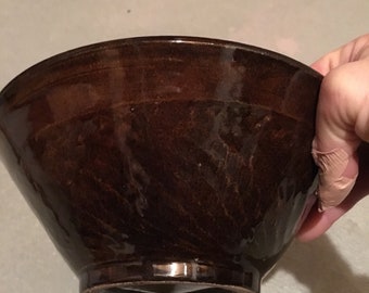 Tazón marrón con parloteo (textura) en el costado.