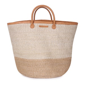 May include: A large, woven tote bag with tan leather handles and a tan leather trim. The bag is made of natural fibers and has a two-toned design with a lighter top and a darker bottom.