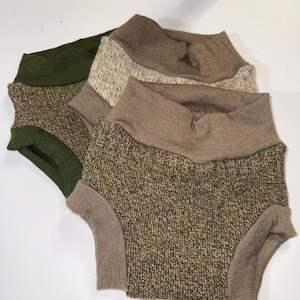 Puede incluir: Tres pares de pantalones cortos de bebé de punto en tonos verdes, marrones y beige. Cada par presenta una cintura y aberturas de las piernas acanaladas. Los pantalones cortos están hechos de tejido de punto texturizado.