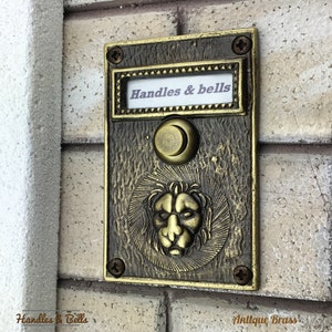 Solid Brass Doorbell Push Button with Bas Relief Lion Head in Antique Brass Gloss Finish.
