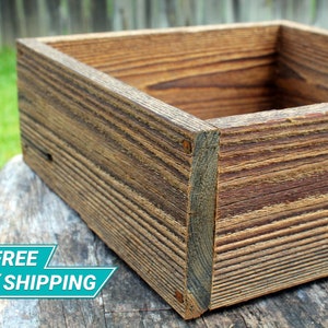 May include: A rustic wooden box with a natural wood finish. The box is made of reclaimed wood and has a distressed look. The box is empty and ready to be filled with your favorite items.