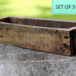 May include: Set of five rustic wooden planter boxes. The boxes are made of weathered wood and have a natural, unfinished look. They are perfect for adding a touch of rustic charm to your home or garden.