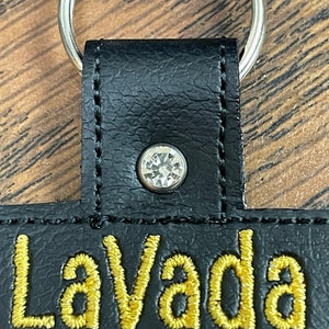 May include: Black leather keychain with a gold embroidered word "LaVada" and a clear rhinestone.