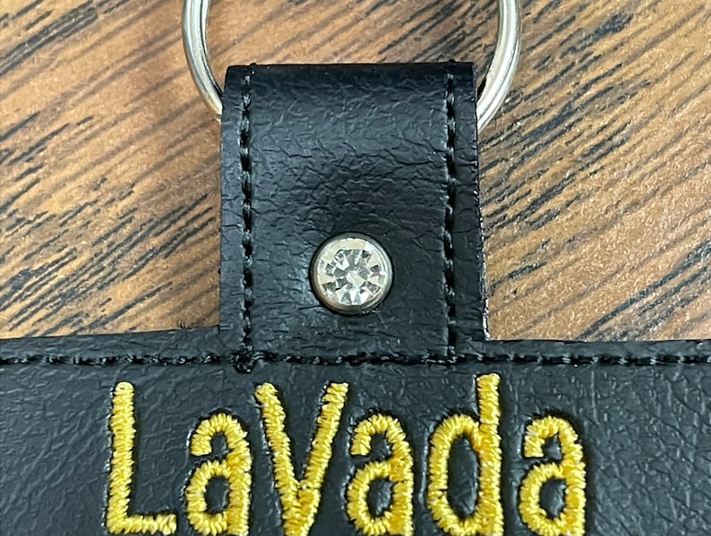 May include: Black leather keychain with a gold embroidered word "LaVada" and a clear rhinestone.