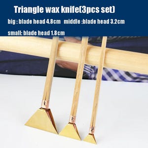 May include: A set of three triangle wax knives with wooden handles and brass-coloured blades. The image text indicates blade head sizes: 4.8cm, 3.2cm, and 1.8cm. These knives are designed for wax carving and sculpting.