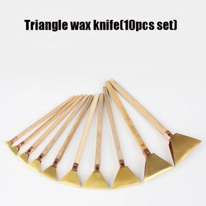 May include: A set of ten triangle wax knives with wooden handles and brass-coloured blades. The text "Triangle wax knife (10pcs set)" is displayed at the top of the image. The knives are arranged in a fan shape.
