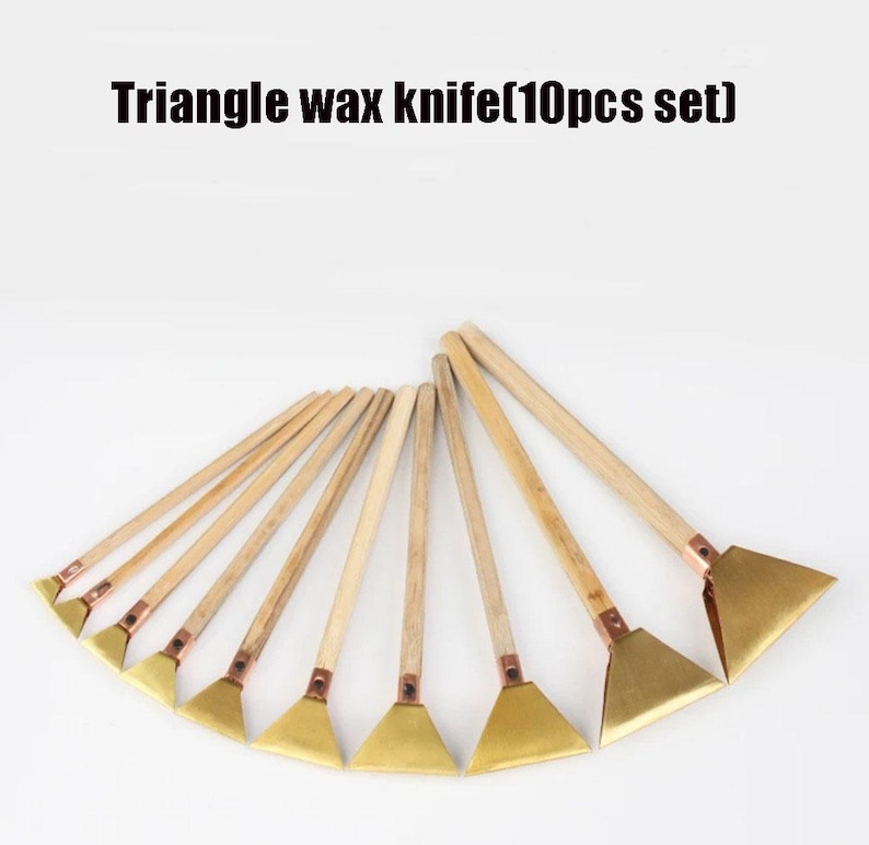 May include: A set of ten triangle wax knives with wooden handles and brass-coloured blades. The text "Triangle wax knife (10pcs set)" is displayed at the top of the image. The knives are arranged in a fan shape.