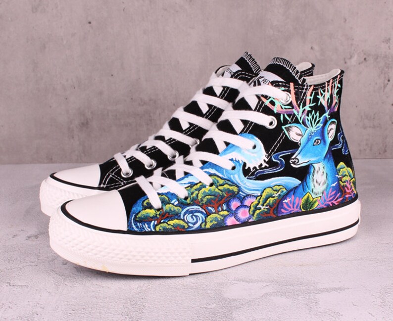 May include: Black high-top canvas sneakers with a hand-painted design featuring a blue deer, waves, and green trees.
