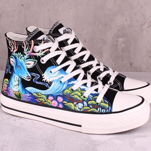 May include: Black high-top canvas sneakers with a hand-painted design featuring a blue deer, waves, and flowers.