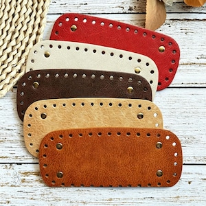 May include: A set of five rectangular faux leather bag bases in red, cream, dark brown, tan, and light brown. Each piece features rounded corners, pre-punched stitching holes along the perimeter, and four small metallic studs at the corners.