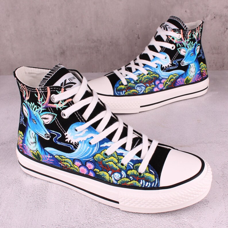 May include: Black high-top canvas sneakers with a white sole. The sneakers feature a colorful design of a deer, waves, and trees.