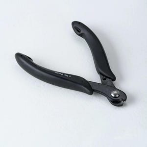 May include: Black wire cutters with curved, ergonomic handles. The tool has a pivot point and a cutting edge. The text "Top Quality" is printed on the handle.