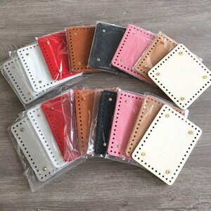 May include: A collection of rectangular bag bases in various colors including white, red, brown, black, and pink. Each base features pre-punched holes along the perimeter and four gold-toned metal feet attached to the corners, all individually wrapped.