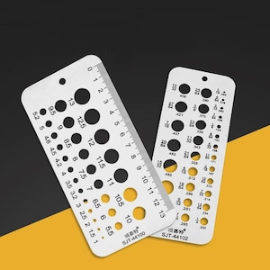 May include: Two metal hole gauges with black holes of varying sizes. One gauge has measurements in inches and the other in fractions. The gauges have the text "SJT-44100" and "SJT-44102".