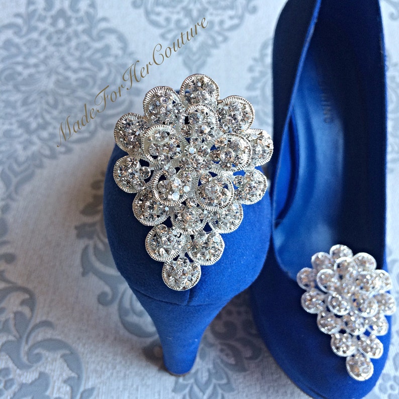 K&ouml;nnte beinhalten: Ein Paar royalblaue High-Heel-Schuhe mit einer silbernen Strassverzierung an jedem Zeh.
