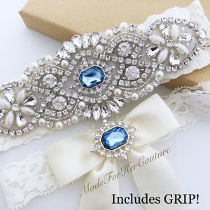 Rhinestone and pearls applique on ivory lace accented with a light blue stone in the center for the keepsake garter. Toss garter has a 3-inch-wide bow with a light blue stone surrounded with small rhinestones.